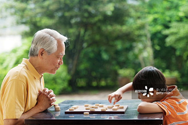 grandfatherandgrandsonplayingxiangqichinesechess创意图片