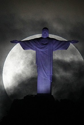图为上周日凌晨超级月亮在里约热内卢的救世主耶稣基督雕像后显现