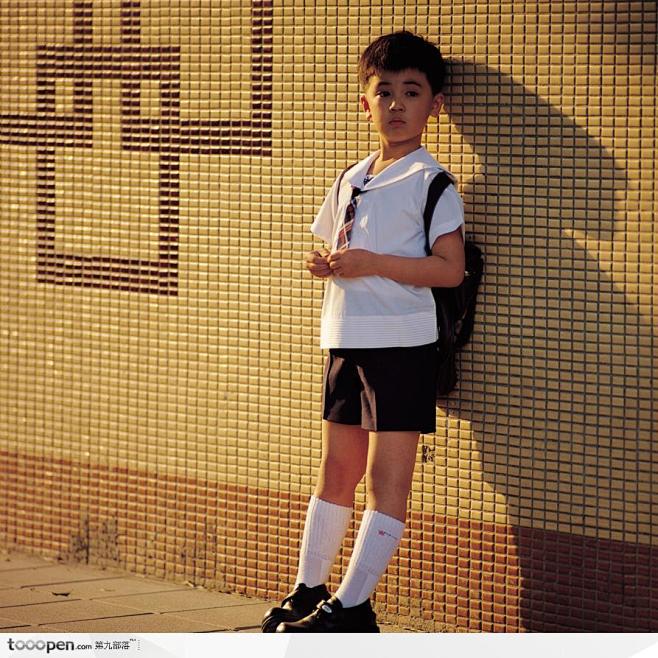 靠着墙壁的小男孩