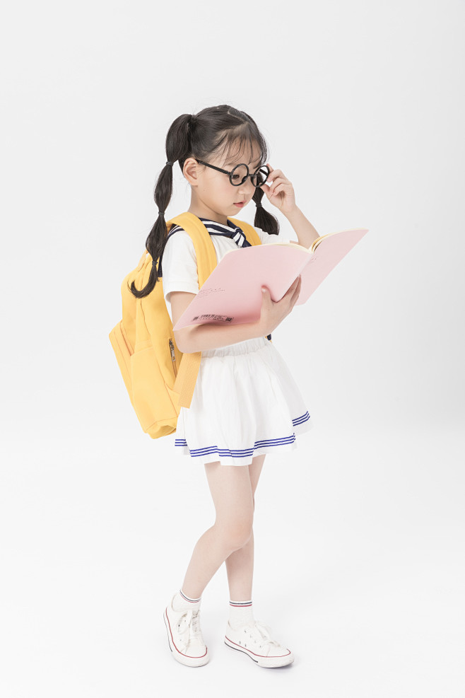 小孩学生背书包上学的小女孩读书看书戴眼镜孩子